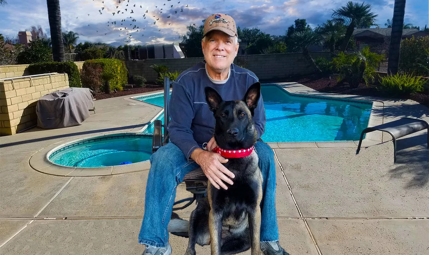 Mark Karge at by the pool at his home with his Malinois